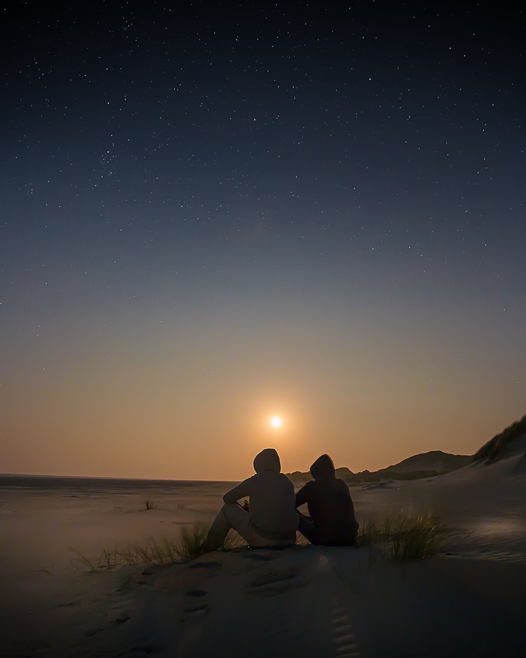 A couple watching the sunset together on the beach